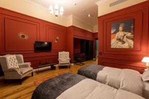 a bedroom with red walls and a bed and a television at Boutique Hotel Cocosul de Aur in Târgu-Mureş
