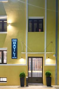 um edifício amarelo com um sinal na lateral em The Mavili urban stay em Tessalónica