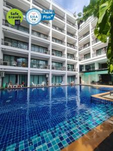 una piscina de hotel frente a un edificio en Paripas Patong Resort - SHA Extra Plus en Patong