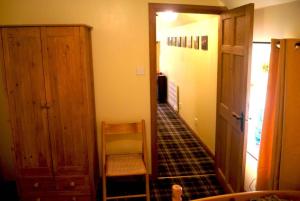 a hallway with a chair and a door to a room at Deveron Valley Cottages in Marnoch