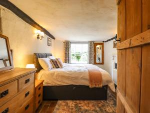 a bedroom with a bed and a window at The Abbey Cottage in Cockfield
