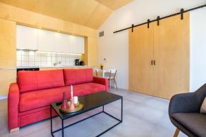 un soggiorno con un divano rosso e un tavolo di Ahirona a Theológos