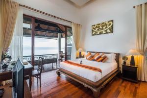 a bedroom with a bed and a balcony with the ocean at Samui Paradise Chaweng Beach Resort , SHA Plus in Chaweng