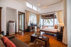 Samui Paradise Chaweng Beach Resort , SHA Plus في شاطئ تشاوينغ: غرفة معيشة مع سرير ونافذة كبيرة