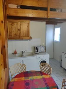 uma cozinha com um lavatório, uma mesa e cadeiras em Maison au Coeur des Sables d'Olonne em Les Sables-dʼOlonne