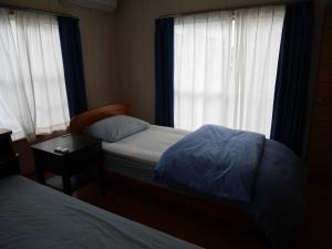 富山市にあるGuest House Inujima / Vacation STAY 3516の小さなベッドルーム(ベッド2台、窓付)