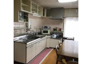 una pequeña cocina con fregadero y microondas en Guest House Inujima / Vacation STAY 3516, en Toyama