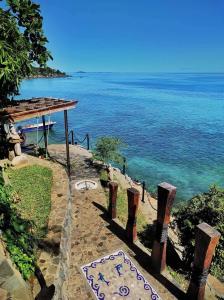 einen Weg zum Ozean mit einem Schild darauf in der Unterkunft Villa Nautilus in Nosy Komba