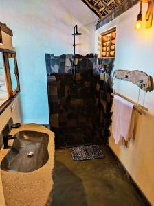 a bathroom with a stone shower with a sink at Villa Nautilus in Nosy Komba