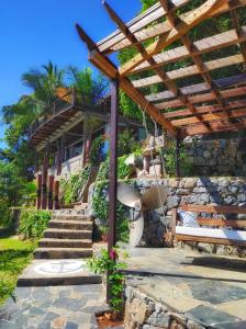 a stone building with a wooden pergola and stairs at Villa Nautilus in Nosy Komba