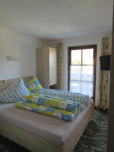 レンゲンフェルトにあるAppartements Grünerのベッドルーム1室(大型ベッド1台、青と黄色の枕付)