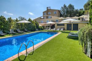 a swimming pool with a lawn chair in front of it at Hotel Costabella in Girona