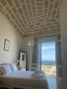 een slaapkamer met een bed en uitzicht op de oceaan bij La camera sul porto in Marettimo