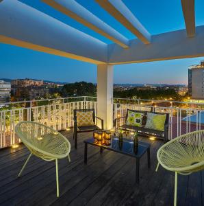 een balkon met 2 stoelen en een tafel op een terras bij Atico Homelike in Granada