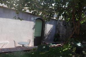 een tafel en stoelen voor een gebouw met een groene deur bij Il Giardino degli Ovali in Fiumefreddo di Sicilia