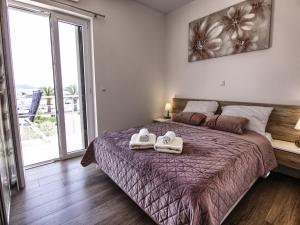 a bedroom with a bed with two towels on it at Apartments Victoria in Pakoštane