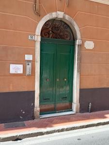 een groene deur in een gebouw met een boog bij Casa Alexandra in centro e a pochi passi dal mare in Imperia