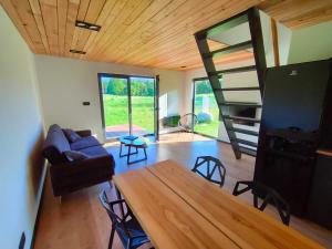 a living room with a couch and a table and chairs at Czarny Domek Mazury in Pozezdrze