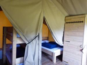 a bedroom with a tent and two bunk beds at Minicamping de Vrolijke Flierefluiter in Someren-Heide