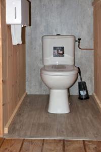 a bathroom with a white toilet in a room at Minicamping de Vrolijke Flierefluiter in Someren-Heide