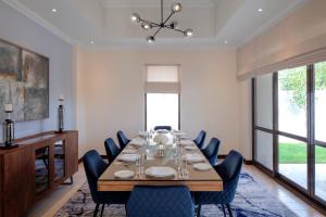 a dining room with a long table and chairs at Dubai Creek Club Villas in Dubai