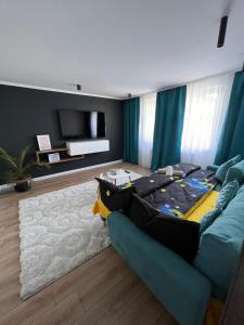 een woonkamer met een blauwe bank met een koffer erop bij Caris Home in Hunedoara