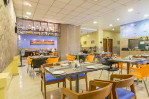 a dining room with tables and chairs in a restaurant at Bangalore Gate Hotel & Conferences in Bangalore