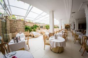 ein Restaurant mit weißen Tischen und Stühlen und einer Glasdecke in der Unterkunft Apartamentos Parque del Sol in Adeje
