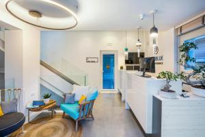 uma sala de estar com uma escada e uma cadeira azul em Mirablue Luxury Residences em Pefkohori