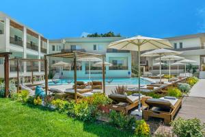 a swimming pool with lounge chairs and umbrellas at Mirablue Luxury Residences in Pefkochori