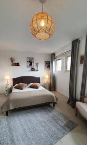 a bedroom with a bed and a chandelier at Chalet entier 110m2 avec vue et sauna à 10 min des pistes in Sainte-Foy-Tarentaise