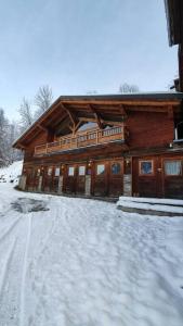 a large wooden house with snow on the ground at Chalet entier 110m2 avec vue et sauna à 10 min des pistes in Sainte-Foy-Tarentaise