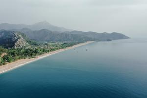 uma vista aérea de uma praia com montanhas ao fundo em Serenity Bungalows em Cıralı