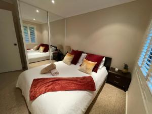 a bedroom with a large bed and a mirror at Lakeside Gem - Lakeview Holiday Home in Lakeside