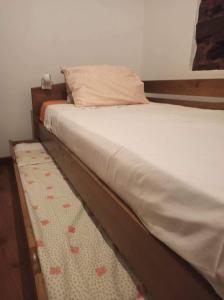a bed with a wooden bed frame and a rug at Cozy Xisto in Mata
