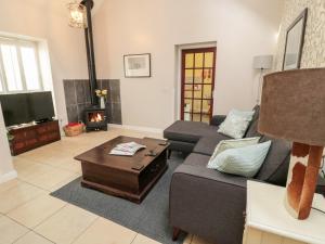 a living room with a couch and a fireplace at Kizzie Cottage in Morpeth