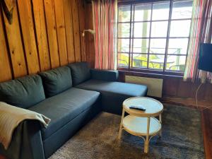 a living room with a blue couch and a table at Lakeland Karelia Fisherman's Paradise in Kesälahti