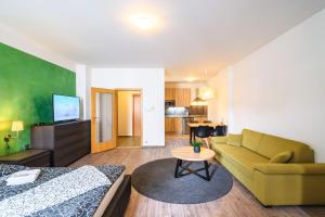 プルゼニにあるPilsner Apartmentsのベッド、ソファ、テーブルが備わる客室です。