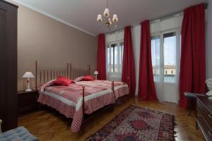 1 dormitorio con 1 cama con cortinas rojas y alfombra en B&B Al Parco Giardini Margherita, en Bolonia