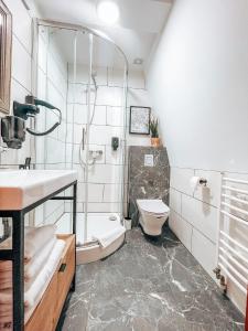 La salle de bains est pourvue d'une douche, de toilettes et d'un lavabo. dans l'établissement Villa Bella Italia, à Mikołajki