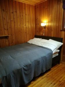 a bedroom with a bed in a wooden wall at Lakeland Karelia Fisherman's Paradise in Kesälahti