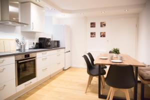 a kitchen with a wooden table and black chairs at Ferienwohnung Am Kahlenberg - Ringsheim in Ringsheim