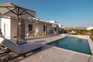 a villa with a swimming pool and a chair and an umbrella at Isalos Villas with private pool, sleeps 4 in Naxos Chora