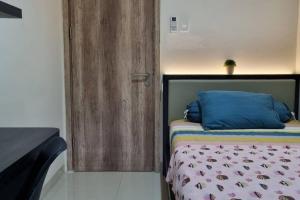 een slaapkamer met een bed en een houten deur bij Apt Pejaten Park Residence 2 BR Grey dgn Netflix, Bathub, Pool in Jakarta