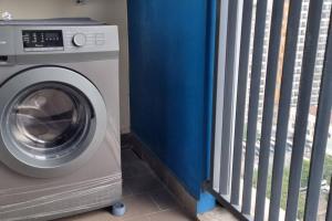 een wasmachine naast een hek bij Apt Pejaten Park Residence 2 BR Grey dgn Netflix, Bathub, Pool in Jakarta