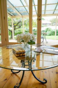 a glass table with a vase of flowers on it at Adelaide Style Accommodation - City to Beach - Free WIFI - Free 3 car parking - Great location in Adelaide