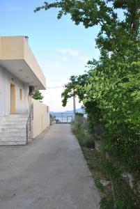 ポリティカにあるArtemis - Marina Apartmentsの階段と木のある建物の横の歩道