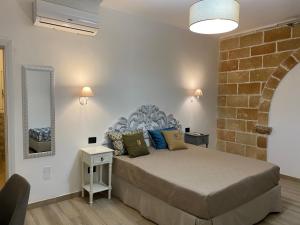 een slaapkamer met een groot bed en een bakstenen muur bij B&B villa Gallo in Torre Squillace