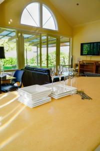 a table with white plates and wine glasses on it at Adelaide Style Accommodation - City to Beach - Free WIFI - Free 3 car parking - Great location in Adelaide