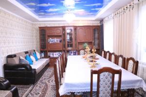 a dining room with a table and a couch at Guest House Oimo in Balykchy